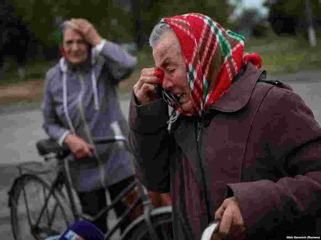 Местные жительницы плачут в освобожденном селе Вербовка. Женщины ждут машину с гуманитарной помощью 