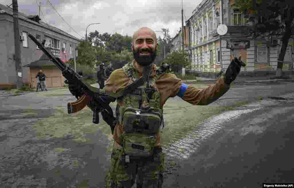 Реакция украинского десантника, увидевшего сослуживцев на улице в недавно взятом городе Изюме, 14 сентября 2022 года. После быстрого контрнаступления в восточной части страны президент Украины Владимир Зеленский отправился в Изюм, где встретился с военными и принял участие в церемония поднятия флага 
