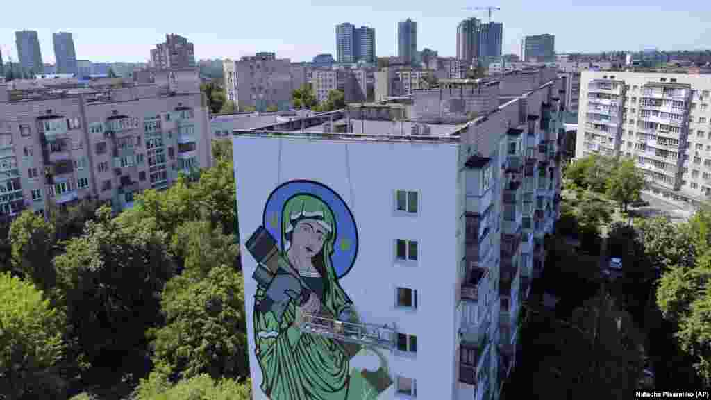 O imagine cu „Sfânta Javelin”: Fecioara Maria legănând o rachetă antitanc în Kiev, mai 2022. 
