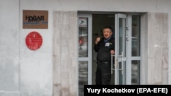 Biztonsági őr áll az orosz Novaja Gazeta moszkvai központjának ajtajában 2021. március 15-én.