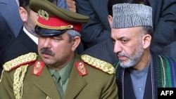 Owganystanyň prezidenti Hamid Karzaý (sagda) bilen general Abdul Reşit Dostum, 2002-njy ýylyň mart aýy.
