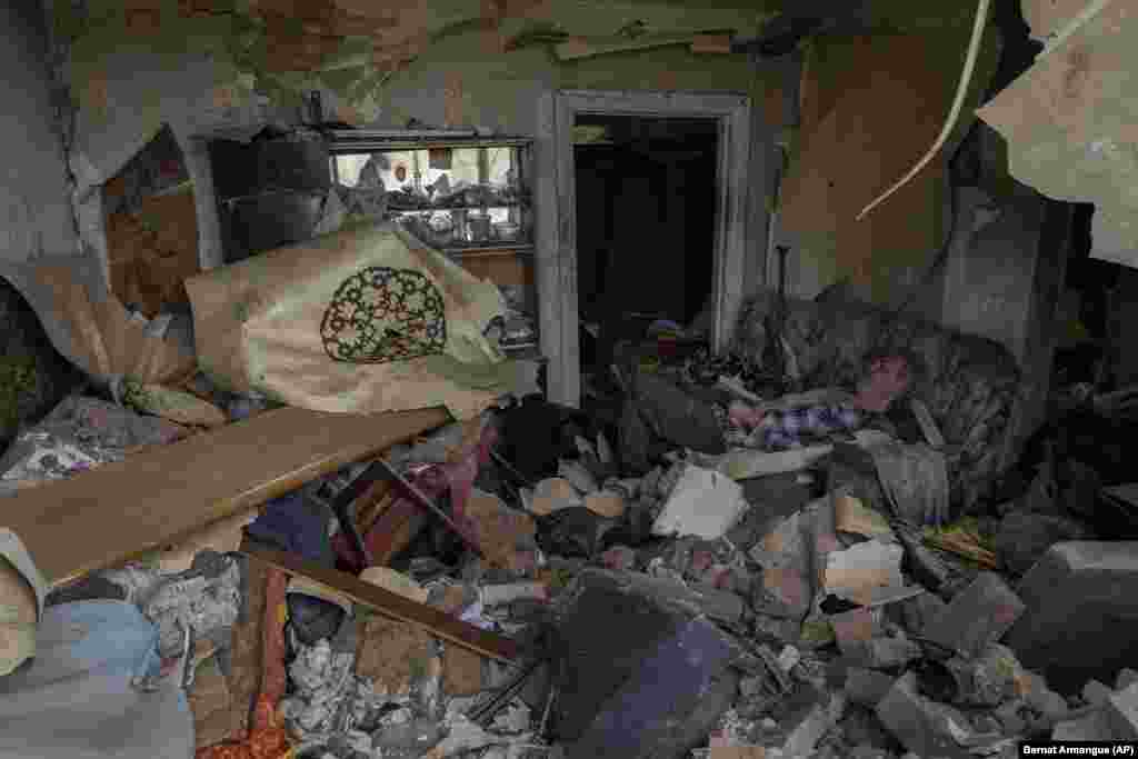 Stanovnik Družkivke na sofi u kući oštećenoj u bombardovanju.