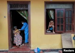 Starija žena prima dozu vakcine Sinopharm u svom domu iz mobilne jedinice za vakcinaciju u Colombu, Šri Lanka, 14. septembra 2021. godine.