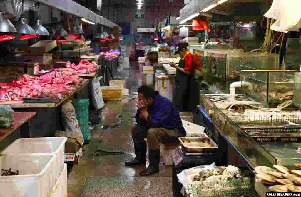 На таких птичьих рынках (на фото — рынок в Пекине) продают разные продукты, например рыбу, мясо и овощи. Рынки называют «мокрыми» из-за того, что покрытие там поливают водой из шланга, полы остаются влажными, продавцы работают в резиновых сапогах.