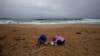 Femei curățind plaja Vilar, la Ribeira, în nord-vestul Spaniei, luni, 8 ianuarie. (Foto: REUTERS/Miguel Vidal) 