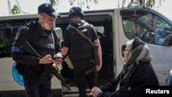 Поліцейський спілкується з місцевими жителями під час евакуації у місті Вовчанськ Харківської області, Україна, 12 травня 2024 року