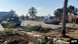 Într-o fotografie publicată de armata israeliană se pot vedea tancurile Brigăzii 401 intrând în punctul de frontieră Rafah, de partea palestiniană, la 7 mai.