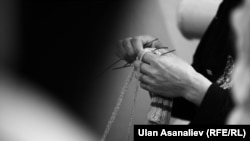 Абакта байпак токуп отурган аял. 