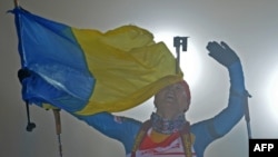 Перемога в жіночій естафеті: Віта Семеренко фінішує з українським прапором на етапі Кубка світу в Обергофі, архівне фото, 2012 рік