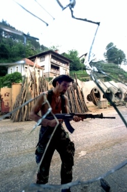 Un sârb căutând luptători musulmani în Srebrenica pe 13 iulie.
