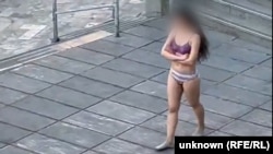Pamje e marrë nga videot që shfaqnin gruan iraniane të zhveshur në publik jashtë një universiteti në Teheran.