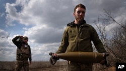 Ushtarët ukrainas bartin predha për të qëlluar në pozicionet ruse në vijën e frontit, pranë qytetit Bahmut, në rajonin e Donjeckut të Ukrainës, më 25 mars 2024.