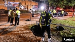 Lucrătorii serviciilor de salvare israeliene la locul atacului cu bombă de duminică.