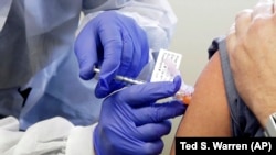 Un voluntar primește o doză în faza clinică de testare a unui potențial vaccin pentru Covid-19