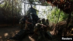 Українські військовослужбовці 148-ї окремої артилерійської бригади ДШВ України ведуть вогонь з гаубиці М777 біля лінії фронту в Донецькій області, Україна, 1 травня 2024 року