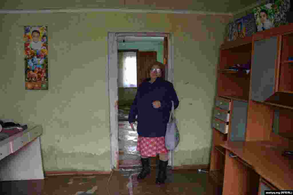 «2004 жылы саманнан салып алған үйіміз еді. Қабырғалары сыз тартып, құлағалы тұр. Басқа барар жеріміз болмаған соң қызымның үйіне көшіп бардық. Қазір бір жерде үш отбасы отырмыз» дейді Махамбет тұрғыны Есенбике Жұмашқалиева. Ақтөбе, 18 сәуір 2017 жыл.