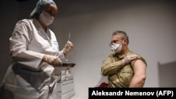 Медицина қызметкері азаматқа "Спутник V" вакцинасын салғалы жатыр. Мәскеу, Ресей, 18 қаңтар, 2021 жыл.