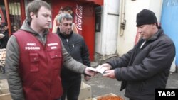 Росія - Працівник федеральної міграційної служби перевіряє документи заробітчан-будівельників