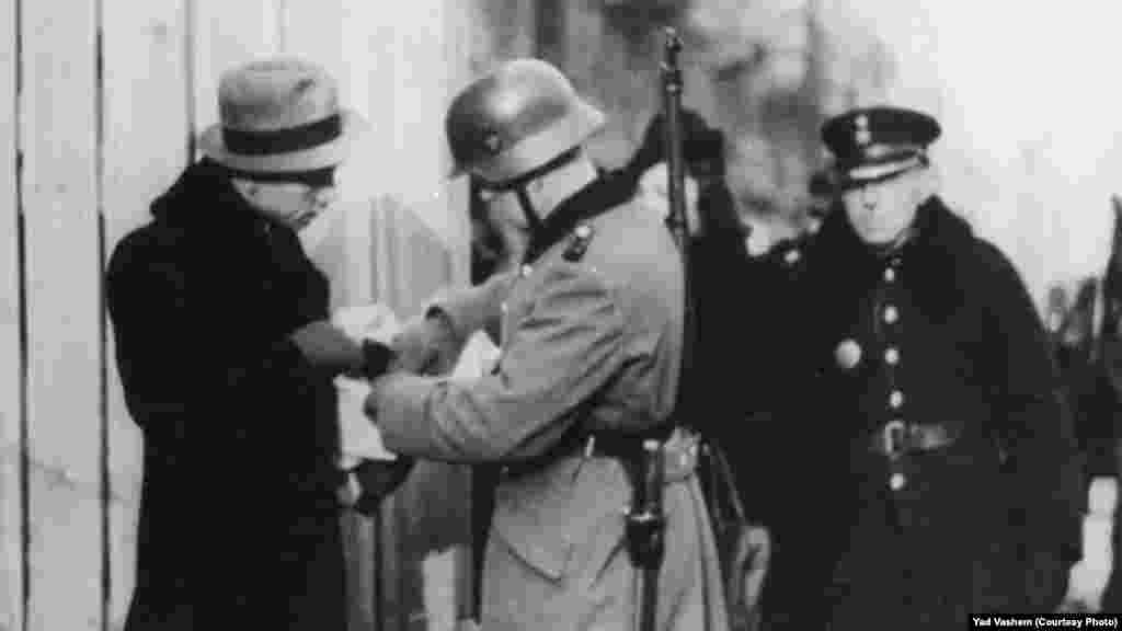 Немски войник проверява документите на евреин. По време на боевете загиват около 6000 евреи, 7000 са убити от немски войници, още толкова са транспортирани в концентрационния лагера в Треблинка, а останалите 36 000 евреи се озовават в лагерите Аушвиц и Майданек (близо до Люблин). Снимка: Дж. Дж. Хайдекер