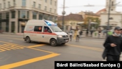 Hagyományos mentőautó elől térnek ki a gyalogosok a budapesti Kálvin téren 2020. november 12-én.