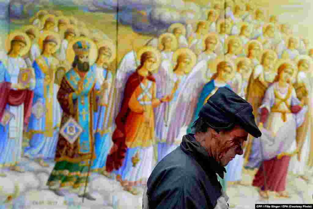 Czech Press Photo Photograph of the Year: A man wounded in clashes in Kyiv, Ukraine, walks past a religious painting. (epa/Filip Singer) 