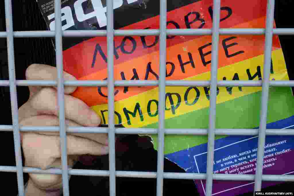 Руски активист за геј права со постер на кој пишува „Љубовта е посилна од хомофобијата!“ додека седи во полициско комбе по притворот за време на неовластениот митинг за геј права во центарот на Москва, на 25.05.2013 година.