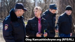 Полицейские ведут в отделение участника митинга