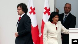 Gürjüstanyň premýer-ministri Irakli Kobakhidze (çepde) we prezidenti Salome Zurabişwili kanun babatyndaky jedellerini dowam etdirýärler.