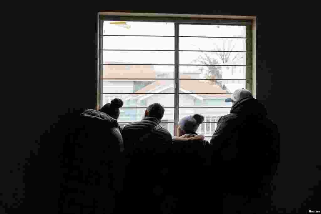 Azilkërkuesit shikojnë nga dritarja e një strehimoreje emigrantësh pasi morën email nga Dogana dhe Mbrojtja Kufitare e SHBA-së (CBP), që i informonte ata se takimet e tyre ishin anuluar, në ditën e inaugurimit për mandatin e dytë presidencial të Trumpit. Meksikë, 20 janar.