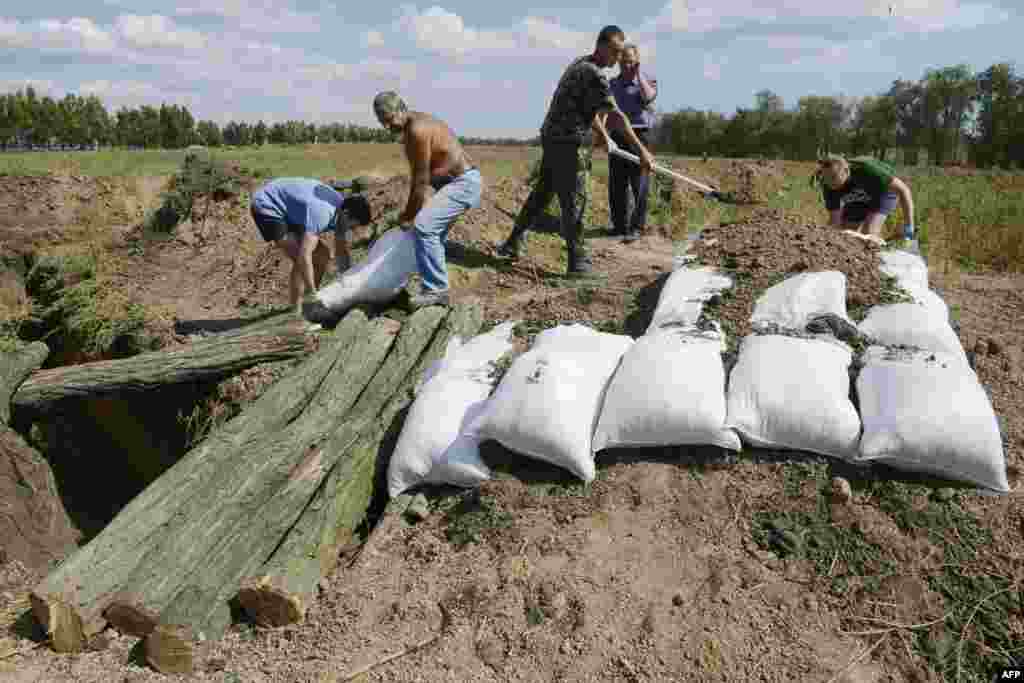 Жителі Маріуполя допомагають українським війсьвослужбовцям рити окопи і робити укріплення мішками з піском, 29 серпня 2014 року 