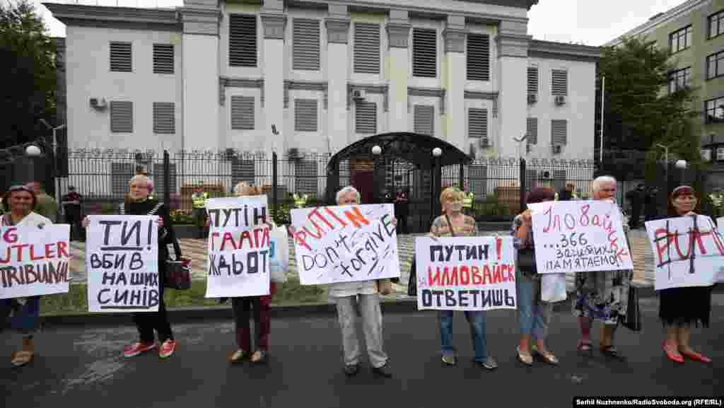 Плакаты в руках участников акции: "Путин, Гаага ждет!", "Ты убил наших сыновей"