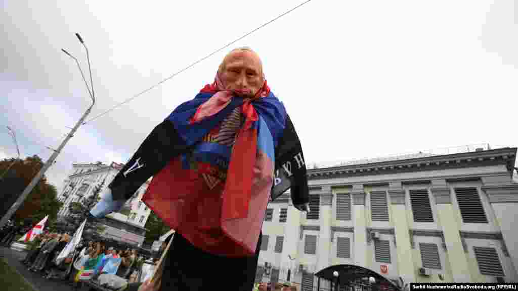 Участники акции у посольства России принесли с собой и сожгли чучело в маске российского президента, завернутое во флаги самопровозглашенных "ДНР" и "ЛНР"