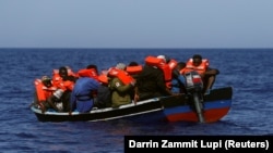 Líbiai migránsok a Földközi-tengerben várnak egy német jótékonysági szervezet által üzemeltetett mentőhajót 2021. augusztus 1-jén