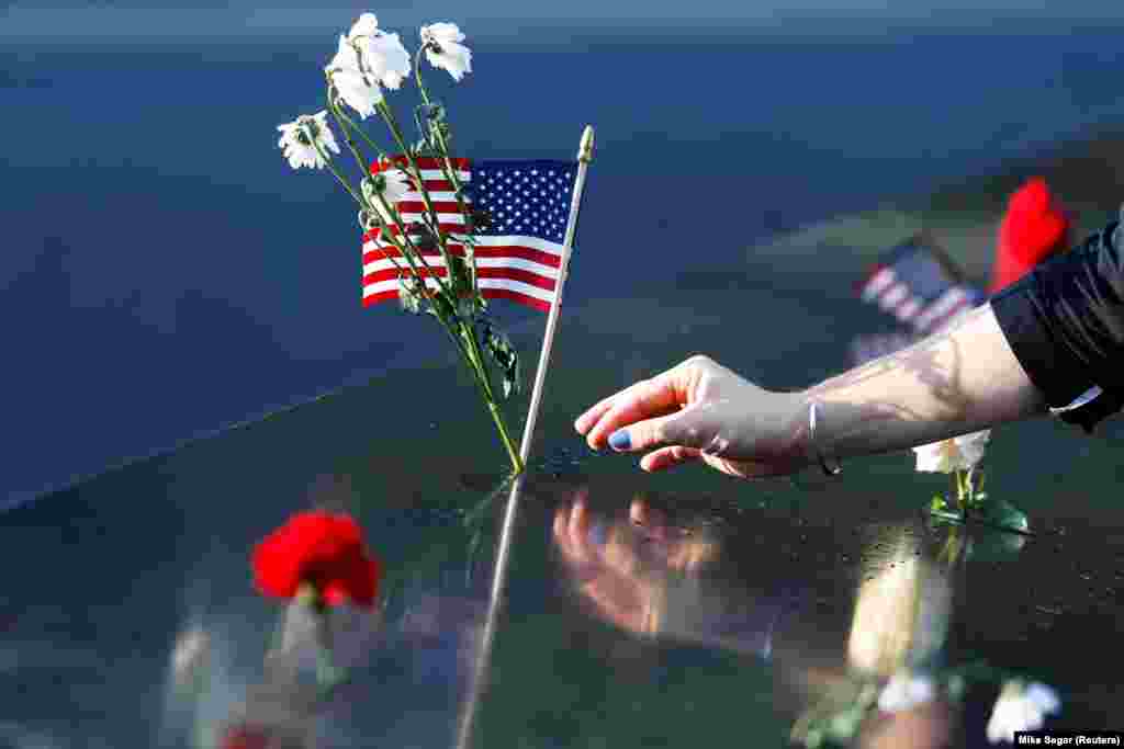 Një grua vendos lule dhe një flamur amerikan në memoralin për viktimat e 11 shtatorit në Nju Jork, teksa Shtetet e Bashkuara shënojnë 20-vjetorin e sulmeve terroriste. 