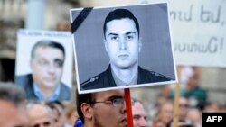 Участники акции протеста против экстрадиции Рамиля Сафарова из Венгрии в Азербайджан держат портрет Гургена Маркаряна, сентябрь 2012 г.