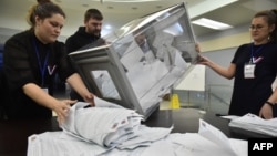 Membrii unei comisii electorale locale numără buletinele de vot la o secție de votare -Novosibirsk, Rusia, 17 martie.