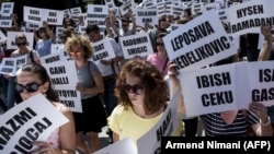 Kosovski građani i građanke drže papire sa imenima nestalih na Kosovu od završetka rata 1999. godine, Priština, avgust 2018