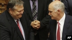 Grčki premijer Jorgos Papandreu (D) prima čestitke od ministra finansija Evangelos Venizelosa nakon glasanja u Parlamentu 21. juna 2011. godine