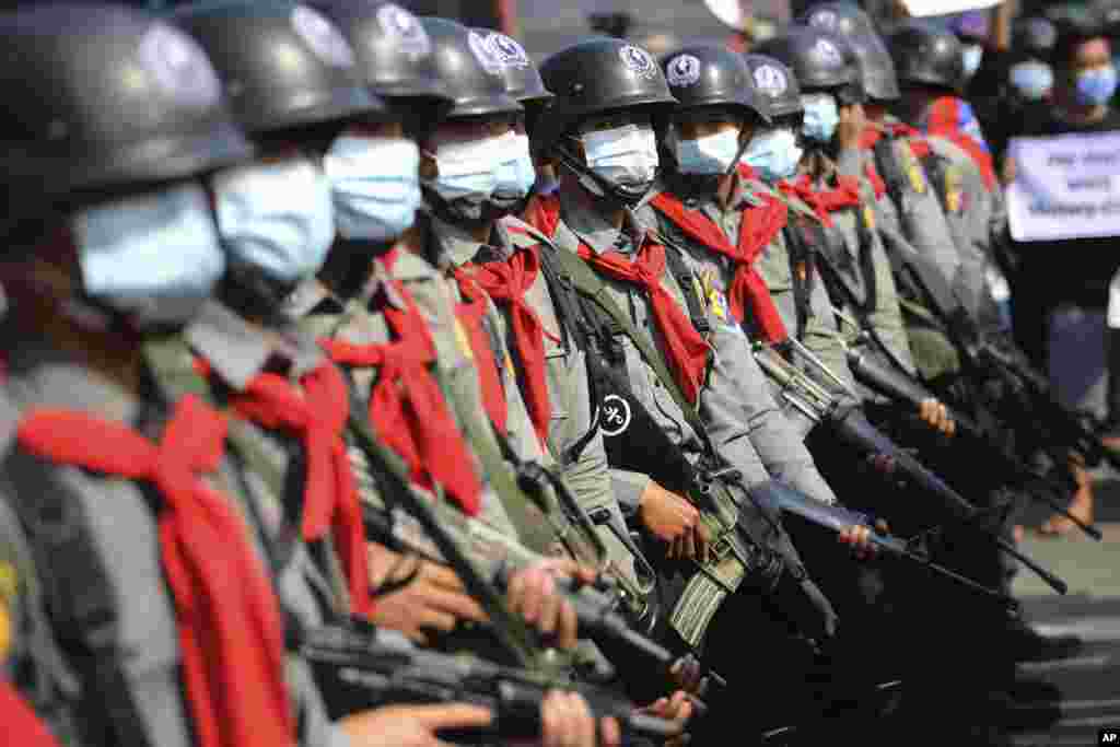 Poliția armată este văzută lângă protestatari în Naypyitaw, Myanmar, luni, 8 februarie 2021.