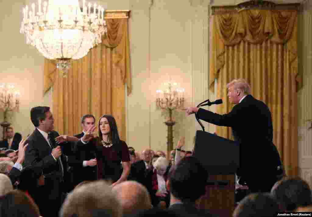 Ақ үй өкілі АҚШ президенті Дональд Трамппен "дауласқан" CNN тілшісі Джим Акостаның микрофонын алып алуға тырысып жатыр. Бұл оқиғадан соң Акостаның Ақ үйге кіруіне тыйым салынды. 7 қараша 2018 жыл 