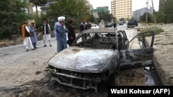 Talibanët hetojnë një makinë të dëmtuar, pas një sulmi me raketa në Kabul, 30 gusht, 2021.