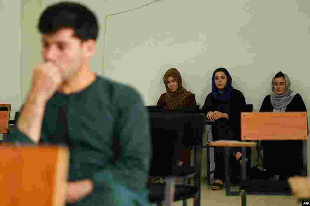 Students listen to a lecture at a private university in Kabul on September 6. The Taliban has decreed that students must be segregated by gender. Other photos from Kabul show male and female students separated by a curtain. 