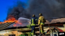 Пожежники гасять пожежу на складі після російського обстрілу в Херсоні, вересень 2023 року 