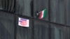 یک پوستر ضدآمریکایی در کنار پرچم جهوری اسلامی بر یک ساختمان دولتی در تهران، آبان ۱۴۰۲