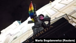 Isus Hristos - monumet din fața bisericii Sfintei Cruci de la Varșovia, învăluit în stagul curcubeu și cu o mască roz, 29 iulie 2020