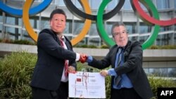 İsveçrədə Pekin Olimpiadasına etiraz aksiyası. Çin Prezidenti Si Cinpinq (solda) və BOK Prezidenti Tomas Baxın maskalarını taxmış etirazçılar
