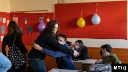 Gimnáziumi osztálytársak köszöntik egymást a jelenléti oktatás első napján a Szent Imre Katolikus Gimnázium és Általános Iskola osztálytermében Nyíregyházán 2021. május 10-én. Jelenleg nem általánosan kötelező az iskolákban a maszkviselés.