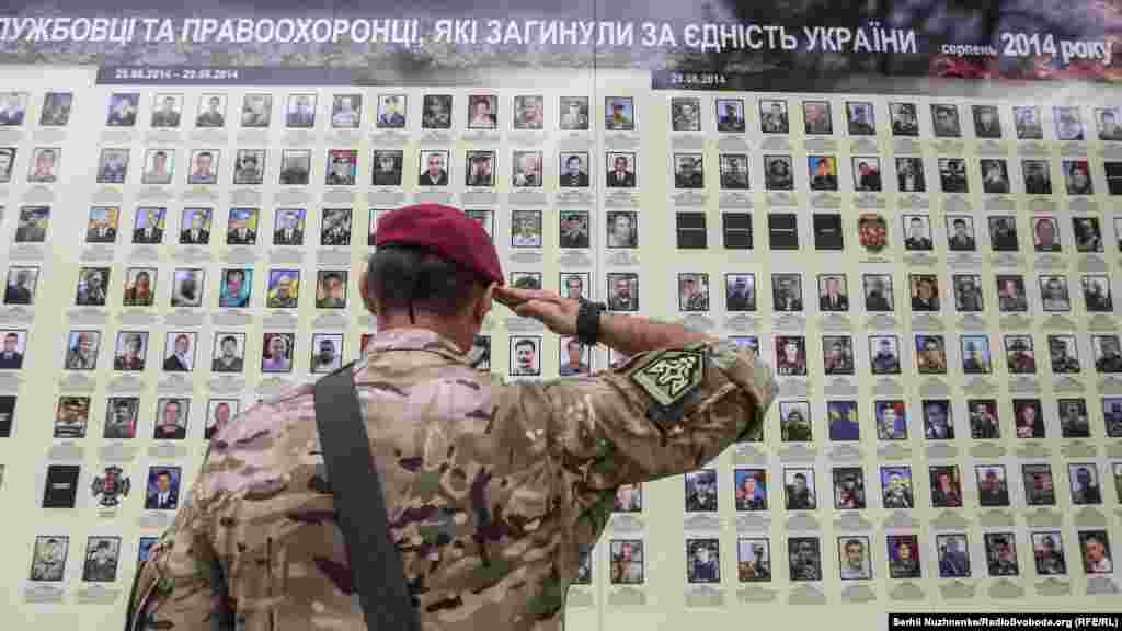 Військовий віддає честь біля меморіалу загиблих бійців у війні з Росією. Київ, 24 серпня 2017 року. Київ, стіна Михайлівського собору УПЦ Київського патріархату, 24 серпня 2017 року ПЕРЕГЛЯНЬТЕ ФОТОГАЛЕРЕЮ: Парад військових і «Хода нескорених»