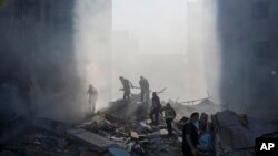 Punëtorët e mbrojtjes civile duke shuar zjarrin pas një sulmi ajror izraelit në periferi të Bejrutit më 15 nëntor 2024. 