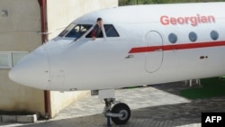 Imagine de arhivă cu un băiat care salută de la fereastra unui avion Yakovlev Yak-42 din epoca sovietică, transformat în grădiniță, Rustavi, Georgia, 29 octombrie 2012.